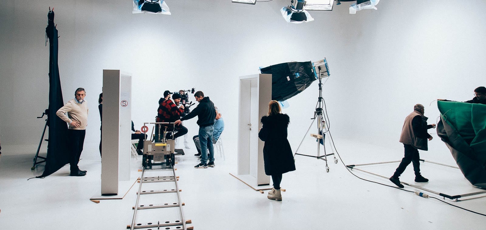 Squareme Mesi medical devices video - the tehcnical crew preparing the set in a white studio with rails and two doors