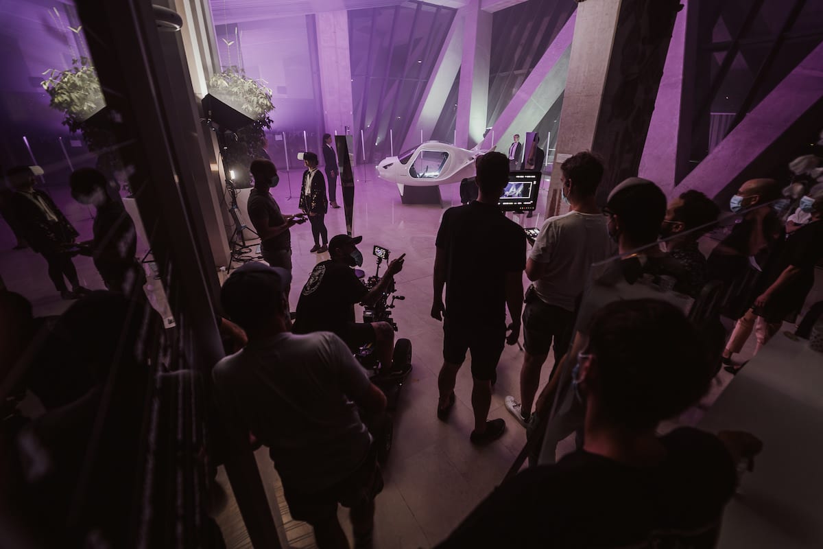 Squareme Triglav Skladi TV ads - production crew filming a futuristic scene with a flight simulator in a modern interior lit with purple light