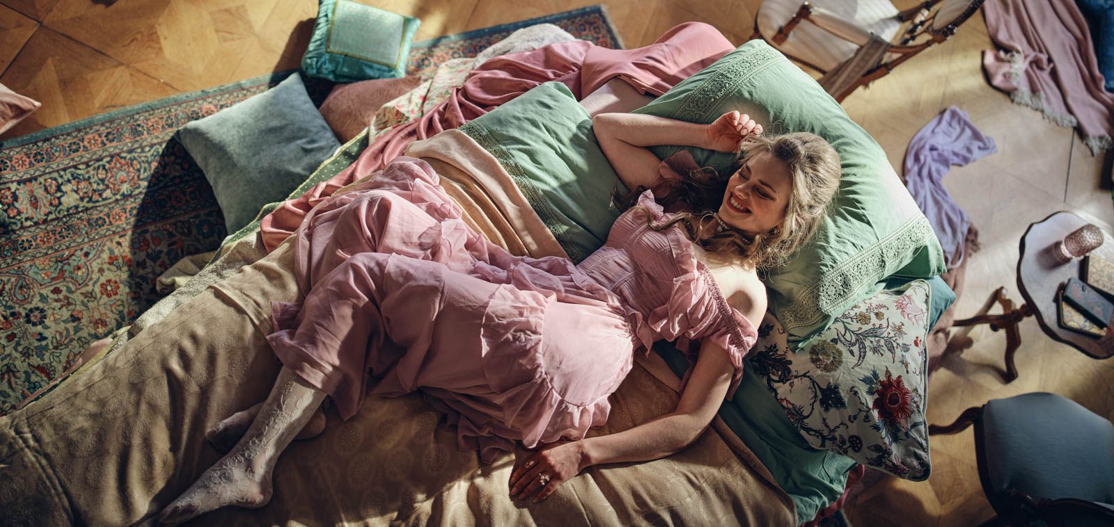 Maja Šebenik, a Slovenian actress, dressed as a princess, laying on a bed whilst filming a commercial for a new Poli Green product.
