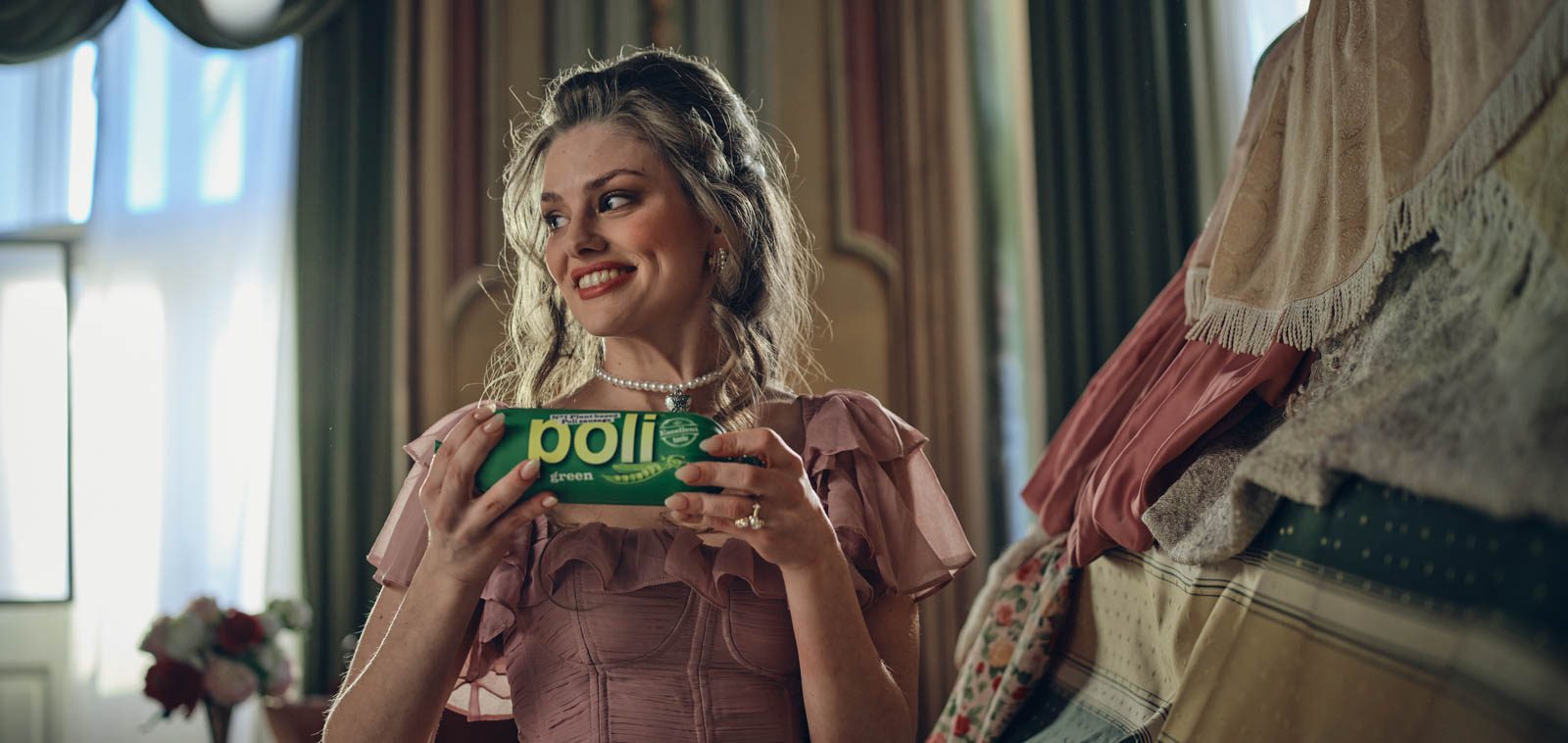 In a room with a castle theme, Maja Šebenik, a Slovenian actress, poses as a princess while holding a new Poli Green sausage.